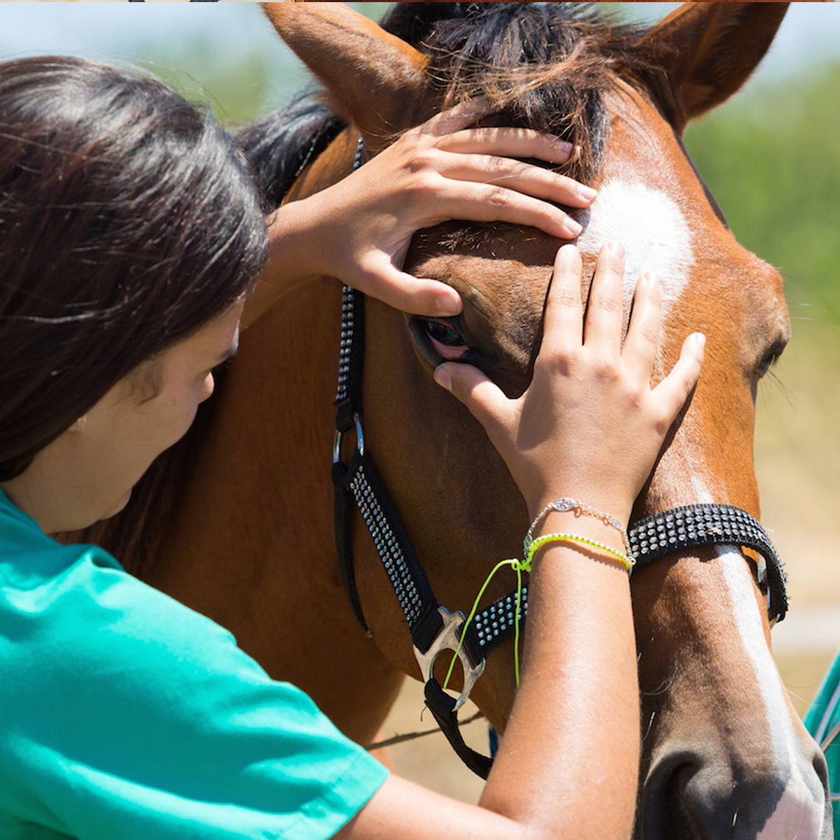 a woman dressed in a green shirt with a horse